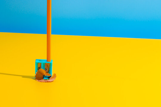 Pencil in blue sharpener on yellow table