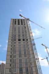 Obraz premium building under construction.construction of a modern office. Construction site with cranes on a blue clear sky background 