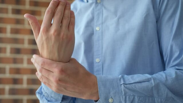 A man massages his hand feeling pain or discomfort, close-up