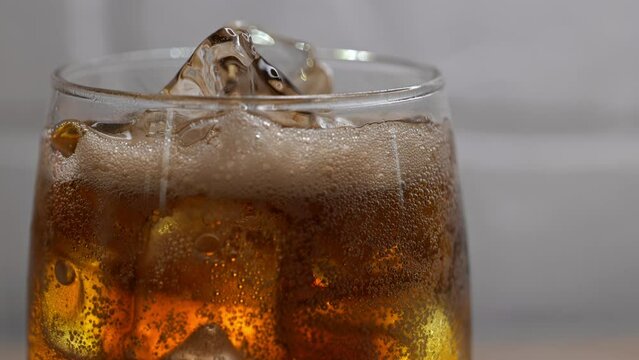 cold drink close up video: cola sparkling in glass with ice