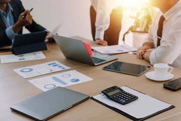 Teamwork with business people analysis cost graph on desk at meeting room.