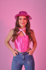 vaqueira beldade sexy da moda fashion com chapéu e top rosa em fundo rosa, expressão alegre e...