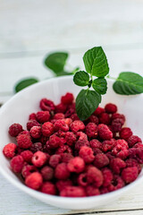 homemade raspberry jam in small jars on a light background. cold season. treatment at home. fresh berries