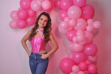 linda garota rica vestida de moda fashion rosa, expressão feliz , fundo com balões rosa 