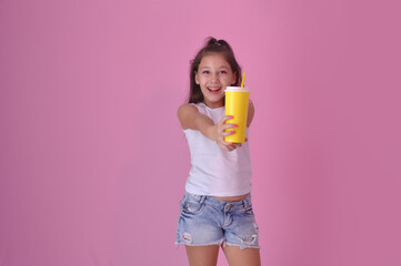 pré adolescente segurando copo amarelo de suco ou água, vida saúdavel e feliz, expressão positiva 