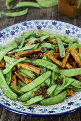 Sugar snap pea stir fry dish with tofu and Chinese five spice blend.