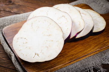 Fresh Sliced Eggplants over Wooden Rustic Background, Purple Round Eggplants