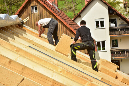 Dachdecker beim Eindecken eines Steildachs mit Holzfaser-Aufsparrendämmung