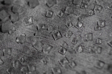 macro of small salt crystals on a metal plate
