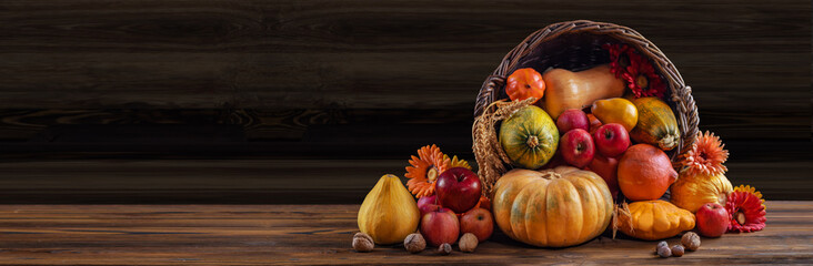 Thanksgiving day background with empty copy space. Pumpkin harvest in wicker basket. Squash, orange...