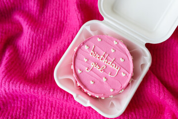 Beautiful bright pink bento cake with an inscription on a pink background. The inscription on the cake Birthday girl .