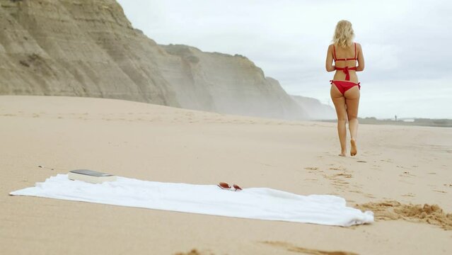 Beautiful blonde girl at the ocean beach - extreme slow motion model photography