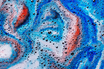 Foam of bath bomb dissolved in water. Soap sud background. Abstract soap foam texture.