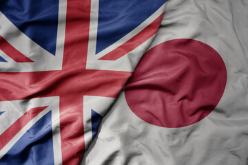 big waving national colorful flag of great britain and national flag of japan .