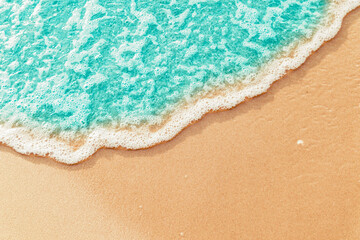 Naklejka na ściany i meble Soft Blue ocean wave on sandy beach. tropical white sand With the sea at the corner.