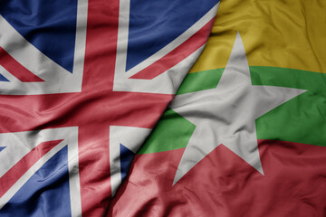 big waving national colorful flag of great britain and national flag of myanmar .