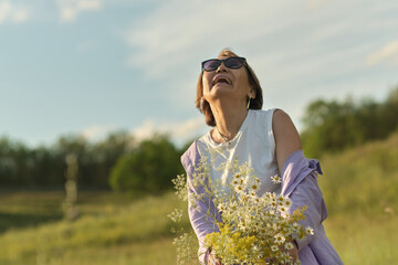 Image of a vibrant senior woman in a lively meadow, a testament to active and healthy living in the golden years