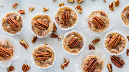 A top down view of homemade salted caramel pecan tarts scattered around.