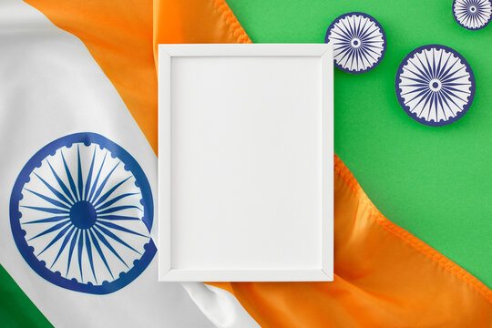 Have a fantastic India Independence Day. Top view arrangement of indian flag, ashoka wheels on pastel green background with blank frame for advert or message