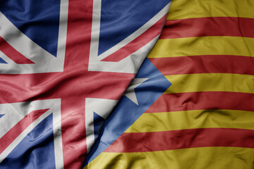 big waving national colorful flag of great britain and national flag of catalonia .