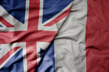 big waving national colorful flag of great britain and national flag of france .