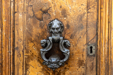 Vintage keyhole on a old wooden door, antique ornamental ornaments for doors. An old decorated vintage door with metal door handle