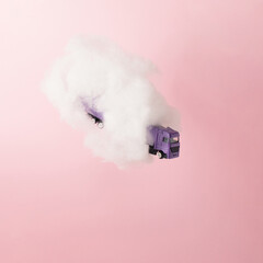 Purple truck in cloud on pink background. Growth, future, development concept. Minimal pink compostition.