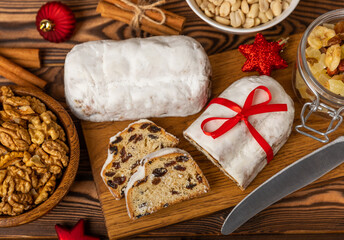 Christmas stollen on wooden background. Traditional Christmas festive pastry dessert. Holiday concept. Dessert, cake, pie with marzipan, nuts and dried fruits. Stollen for Christmas. Spicy pastries.