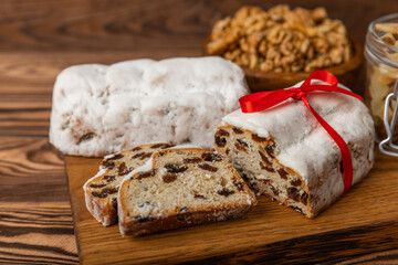 Christmas stollen on wooden background. Traditional Christmas festive pastry dessert. Holiday concept. Dessert, cake, pie with marzipan, nuts and dried fruits. Stollen for Christmas. Spicy pastries.