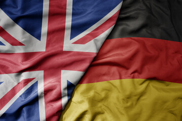 big waving national colorful flag of great britain and national flag of germany .