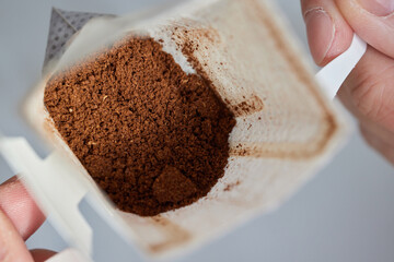 brewing process,a bag filled with boiling water for drip coffee in a cup,top view.