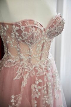 Wedding or graduation dress made of elite fabrics with embroidery, rhinestones and beads. A pink dress on a mannequin.