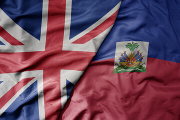 big waving national colorful flag of great britain and national flag of haiti .