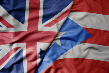big waving national colorful flag of great britain and national flag of puerto rico .