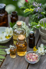 Concept of pure natural ingredients in cosmetology, aromatherapy, naturopathic, herbal extracts and essence. Assortment of glass bottles with organic essential aroma oil with mint, wooden background