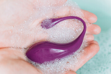 Fototapeta premium Hands washing vibro vaginal and anal massager with soapy foam