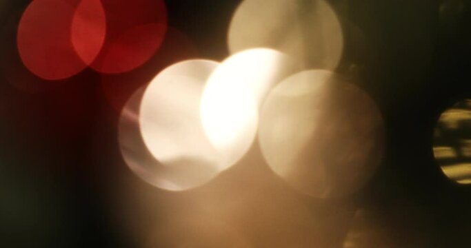 Abstract background of warm Christmas lights with large bokeh circles. Handheld shot with motion.