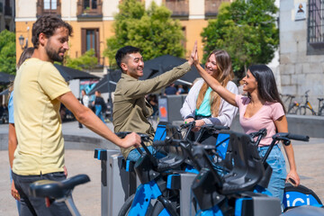 Fototapeta na wymiar Group of multi-ethnic friends in the city next to rental bikes smiling