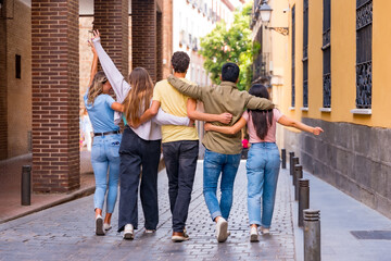 Obraz premium Group of multiracial friends hugging from behind in the city, friendship concept with boys and girls