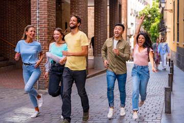 Group of multiracial friends hugging, smiling and jumping in the city, friendship concept with boys and girls