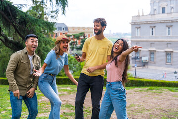 Group of multiethnic friends dancing in a park in the city at a friendship party. summer fun