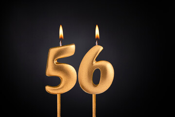 Golden candle 56 with flame - Birthday card on dark luxury background