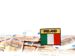 Badge with sign Ireland and Irish flag on Euro bank notes and white background. Finance and banking theme.