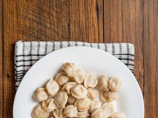 Big portion of Russian dumplings on a white plate. Tasty dinner. Classic west European dish.