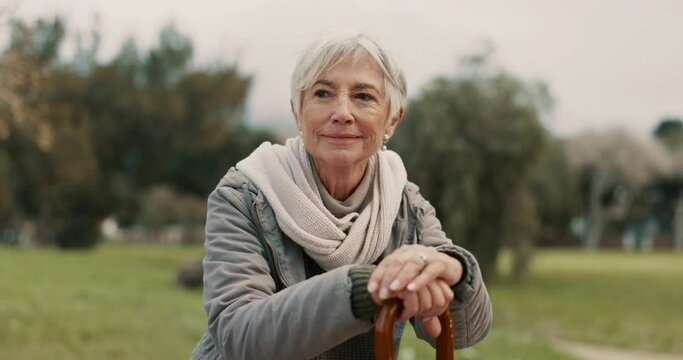 Nature, cane and senior woman in a park for fresh air, exercise or wellness with peace. Calm, smile and elderly female person in retirement with a walking stick for support at an outdoor garden.