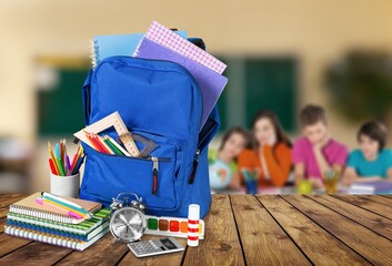 Different school colored supplies on table in classroom