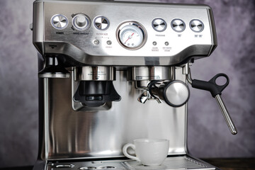 Espresso Coffee Maker with coffee cup against gray wall closeup