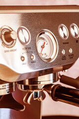 modern steel coffee machine with control buttons and a barometer. Close-up