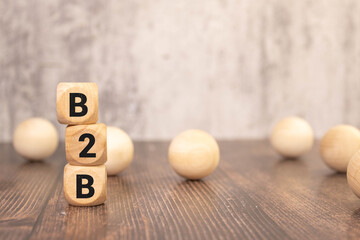Acronym B2B- Business to Business. Wooden cubes with letters isolated on grey background.