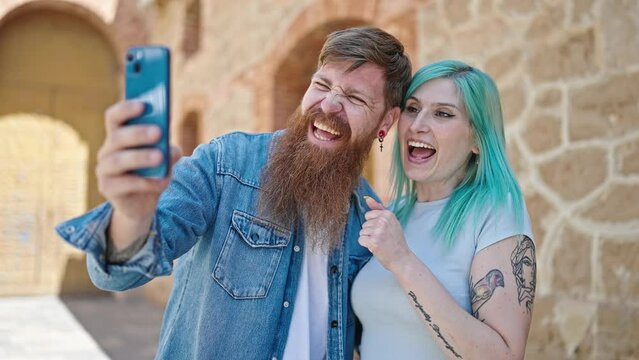 Man and woman couple smiling confident having video call at street